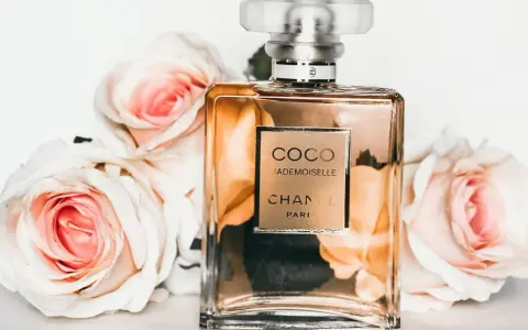 Flakon perfum Chanel Coco Mademoiselle otoczony różowymi różami.