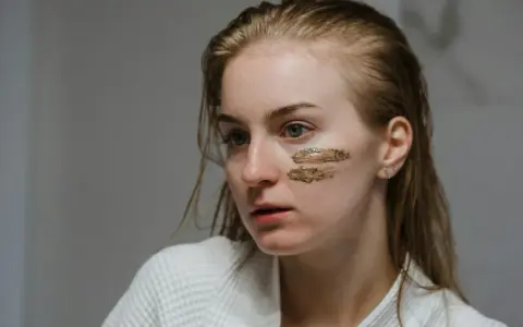 Młoda kobieta z peelingiem enzymatycznym na policzkach. Delikatne złuszczanie dla promiennej cery.