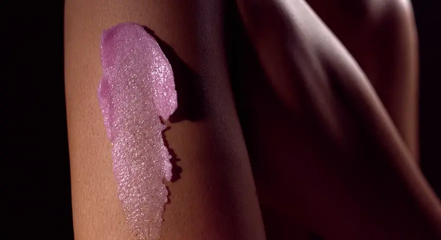 Różowy peeling na skórze nogi. Idealny peeling przed goleniem dla gładkości.