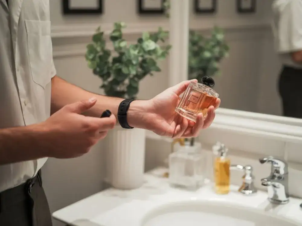 mężczyzna testujący perfumy na nadgarstku